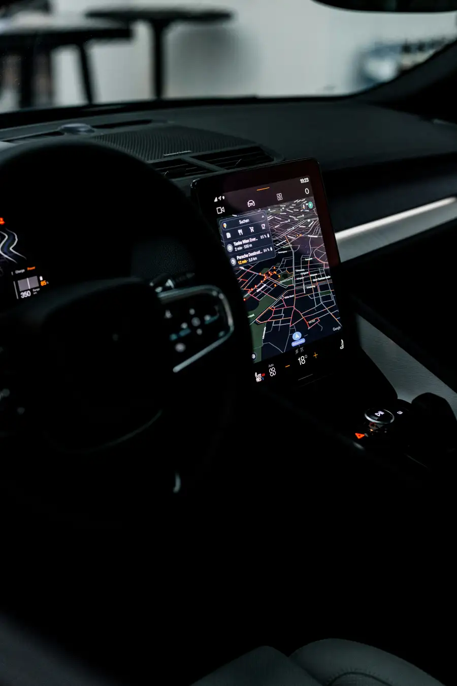 EV dashboard navigation screen showing a route and charging stops at night
