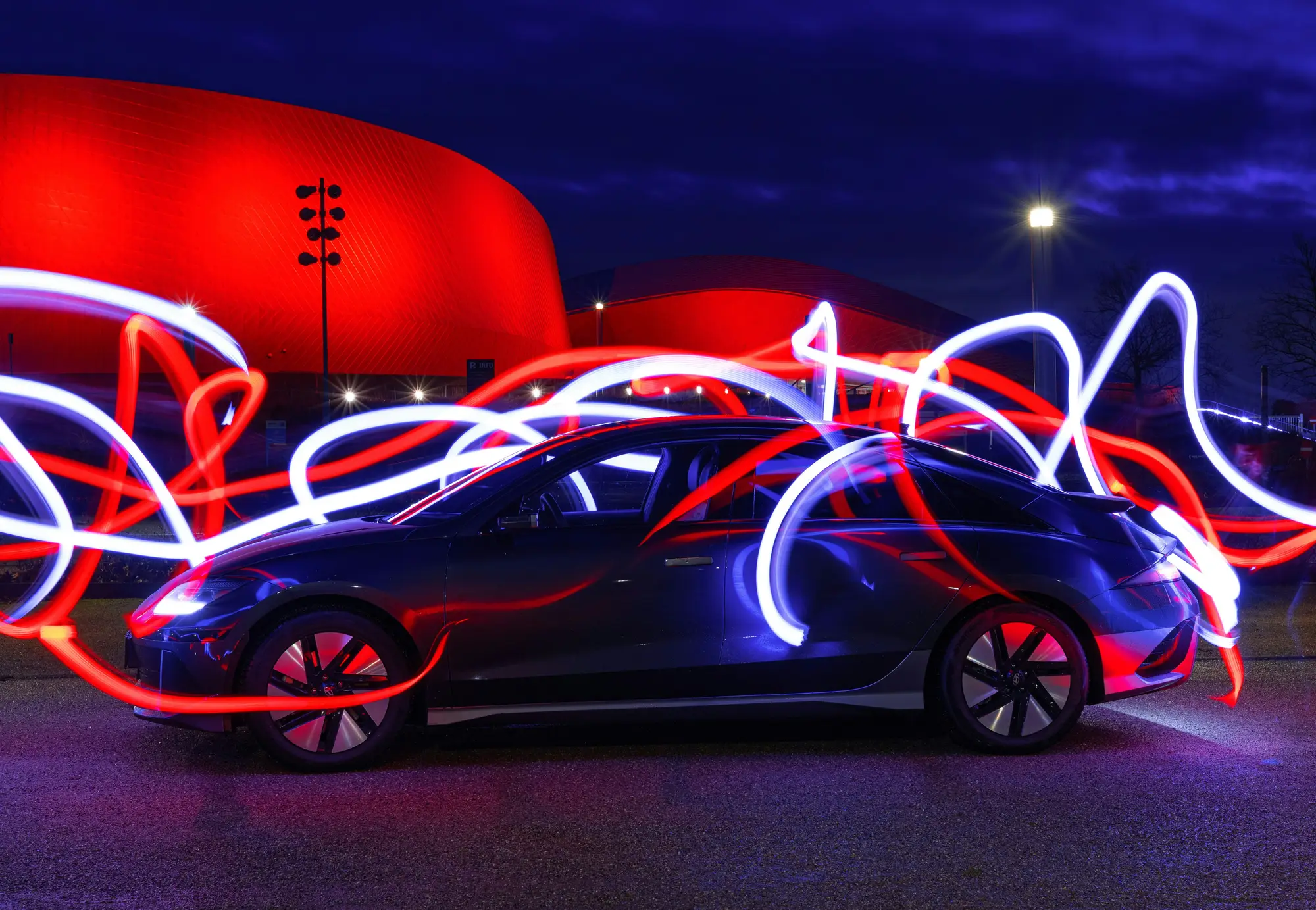 Electric vehicle at night with light trails